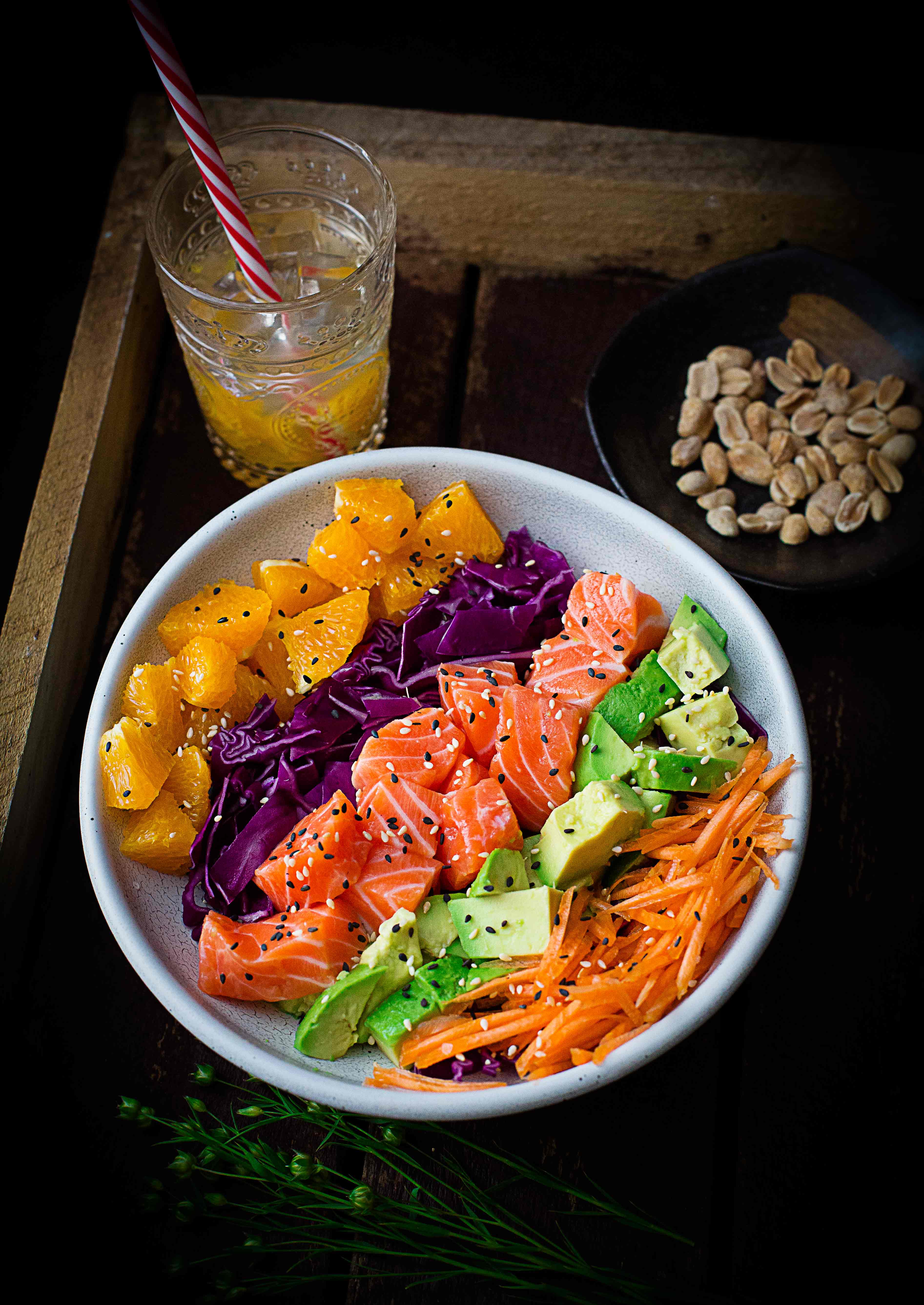 Salmon poke bowl: raw salmon pairing fresh salmon cubes with creamy avocado, sweet carrots, crunchy cabbage, and fruity oranges, all drizzled with a delicious Asian dressing. 