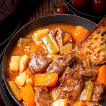 Image of vegetable beef soup in a bowl with the toasted bread.
