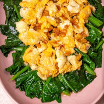 Fried Eggs on the top of Spinach in a pink plate