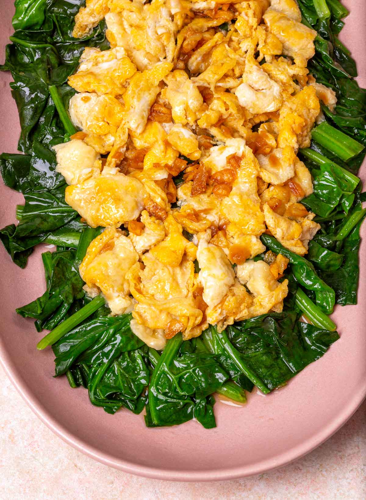 Fried Eggs on the top of Spinach in a pink plate