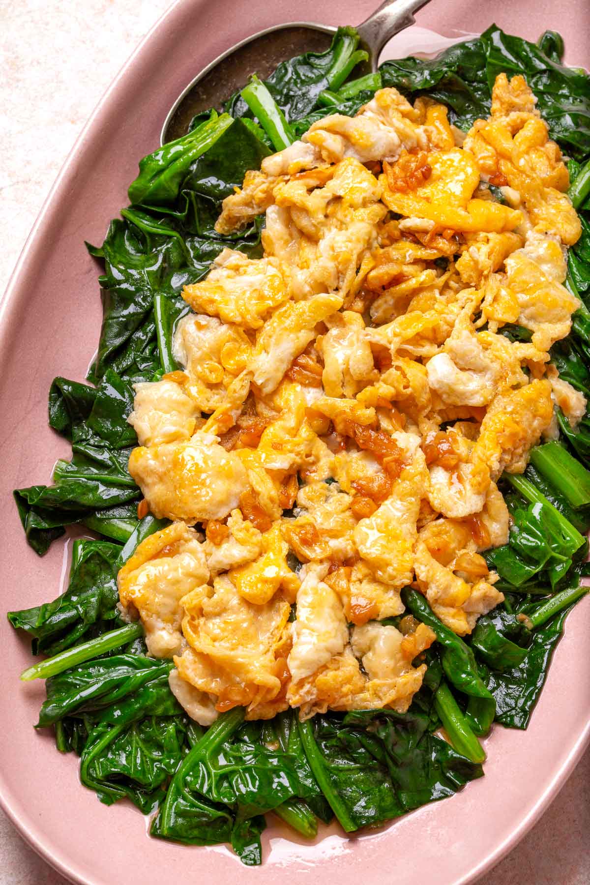 Fried Eggs on the top of Spinach in a pink plate